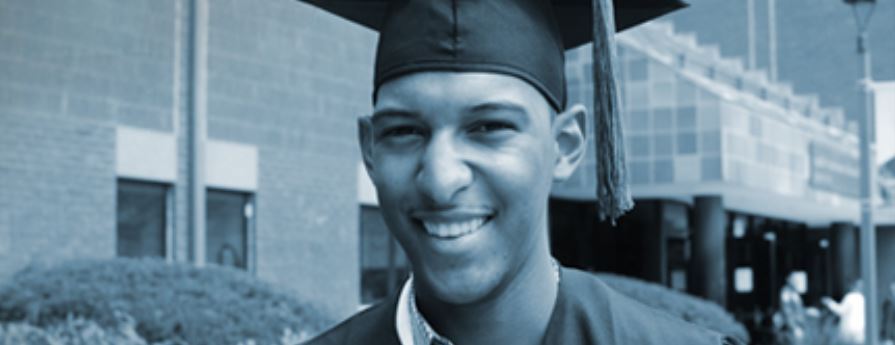 young man in cap and gown outside building