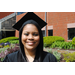 Young lady, Ashley Walker, in cap and gown standing outside smiling at camera