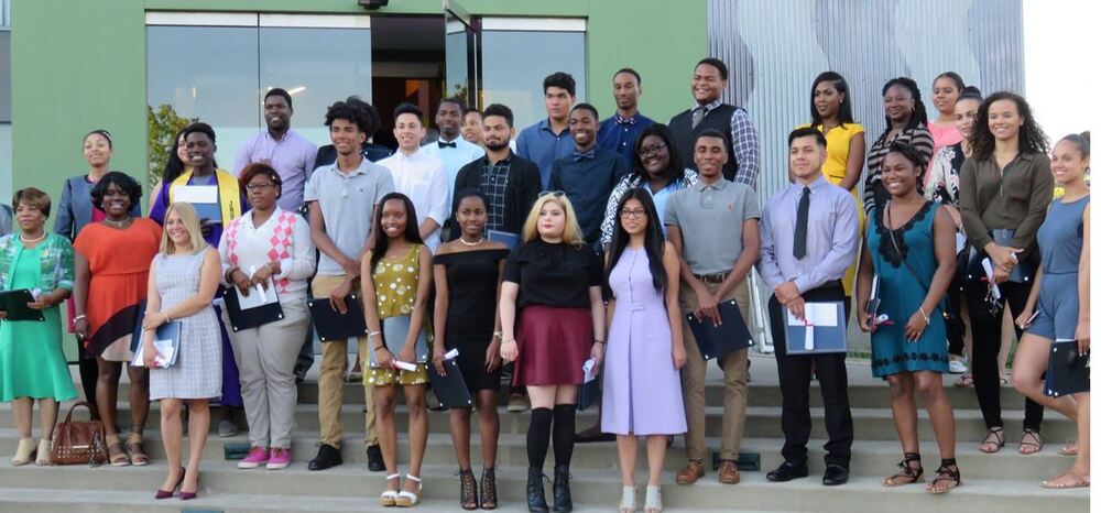 group of young men and women standing on stairs outside