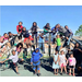 1 classroom of many students outside on playground equipment all looking at camera