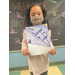 Girl standing in classroom showing her coloring project