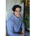 young man, Nicholas Ceja, with dark hair and button down long sleeve shirt sitting in chain smiling at camera