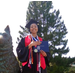 Young lady, Tiahna Spencer,  in graduation cap and gown showing her award and diploma