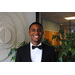 young man, Javed Wright, in suit and bow tie standing inside smiling at camera