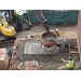 Workers use heavy machines to fill the bricked area with concrete 