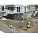 Corner of concrete sidewalk being poured by workers