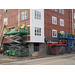 Workers begin to put the white and blue siding on the outside of the building