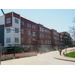 Workers continue to put the white and blue siding on the outside of the building and move on to the next side of the building