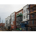 Workers continue to put siding on the building using scissor lift