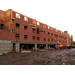 A worker uses a lift to install the sheathing to the outside of the building