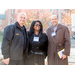 one male police officer smiling with a woman and man 