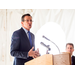 Man with hands grasped, speaking at the podium