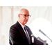 Bald man with glasses speaking at the podium