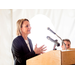 Woman speaking at the podium wearing pearls