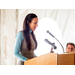 Woman looking down at speech notes while speaking at podium