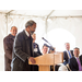 Man hunched over, speaking at the podium 