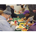 People smiling and eating chips and sandwiches and drinking drinks 