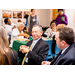 Man laughing while others around him enjoy the food at the luncheon