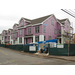 Workers put up siding on the outside of the building