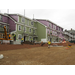 Workers put up siding on the outside of the building and upper story windows are being installed