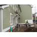 A worker operates a saw as others continue to put up siding 