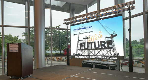 Stage and podium showing opening slide for scholarship reception event